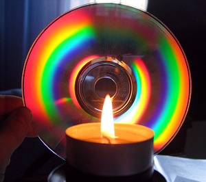 Rainbow (foto del lato inciso di un compact disk illuminato da una candela)